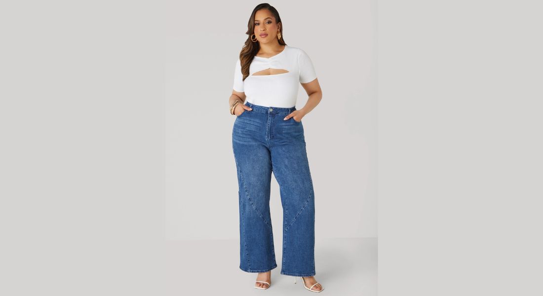 Woman in high-waisted, dark-wash jeans with a structured blazer and a crisp white button-down shirt.