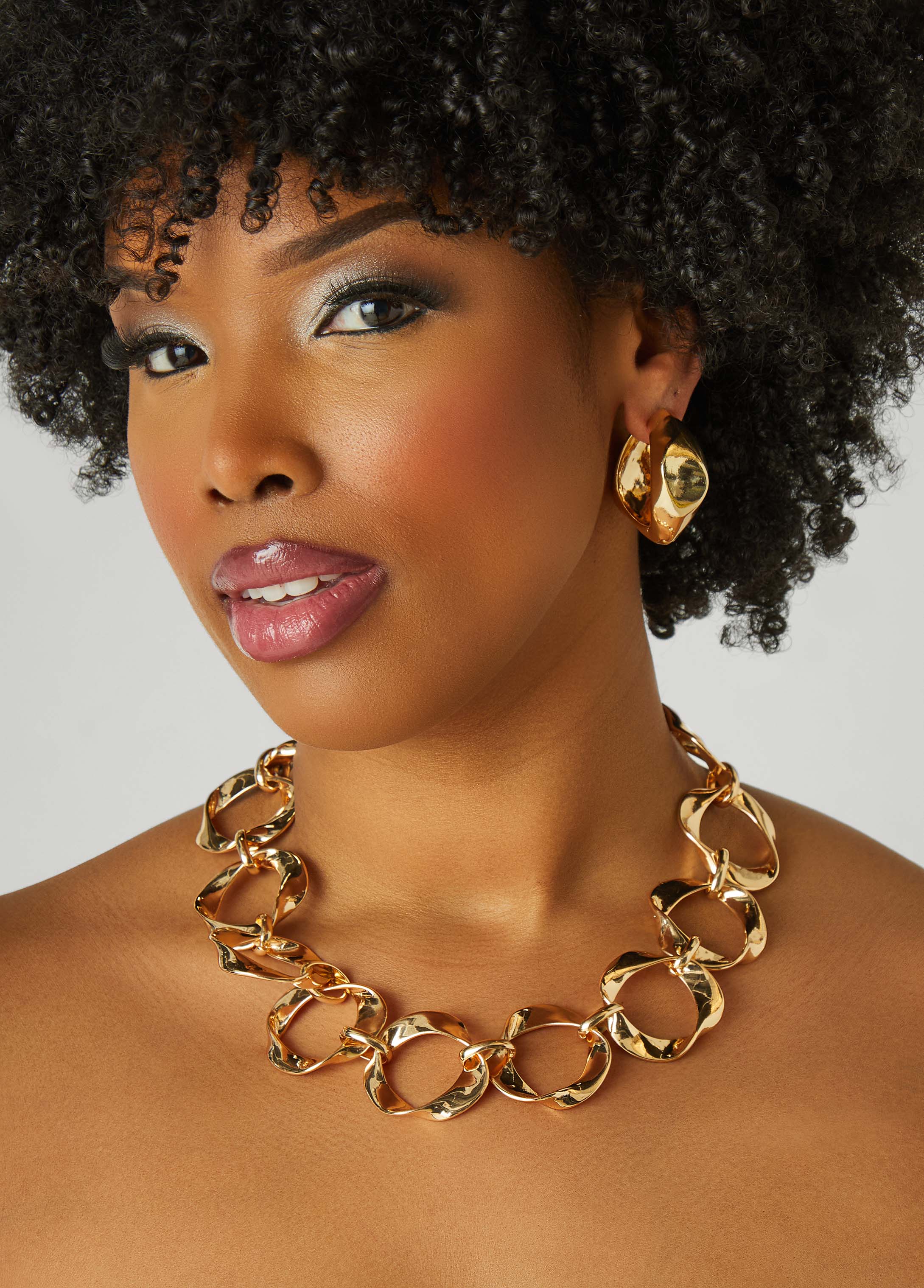 Necklace with twisted rings in gold-tone metal. Lobster-clasp fastening.